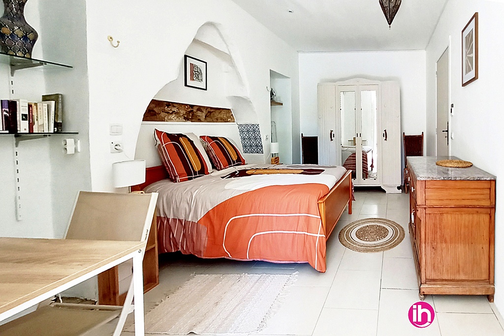 Chambre avec lit double, bureau et rangements.